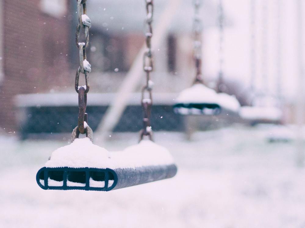 School yard swing dusted with fresh snow