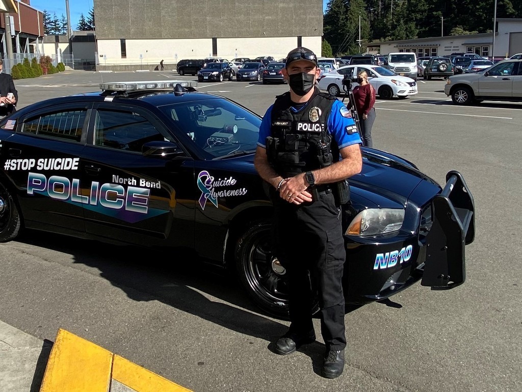Officer Parkhurst standing in front of his newly branded vehicle